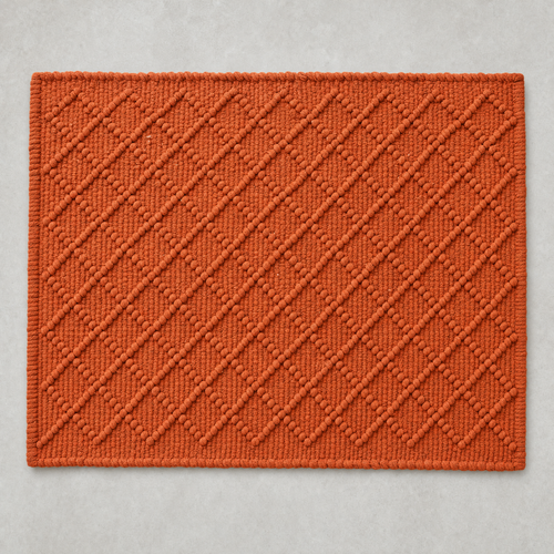 Diamond Mat in seville orange: a hand-woven cotton bath mat with a close knotted diamond weave