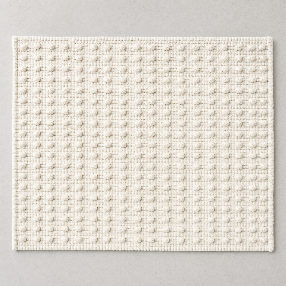 Dot Mat in warm white: a regular grid of raised cotton knots on a flat woven ground