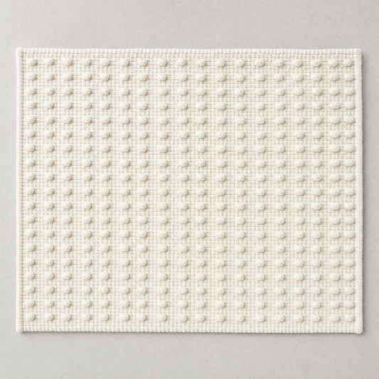 Dot Mat in warm white: a regular grid of raised cotton knots on a flat woven ground