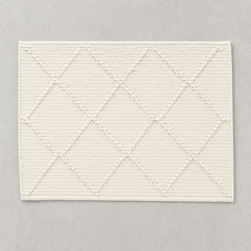 Open Diamond Mat in warm white: knotted diamond outlines over a flat woven cotton ground