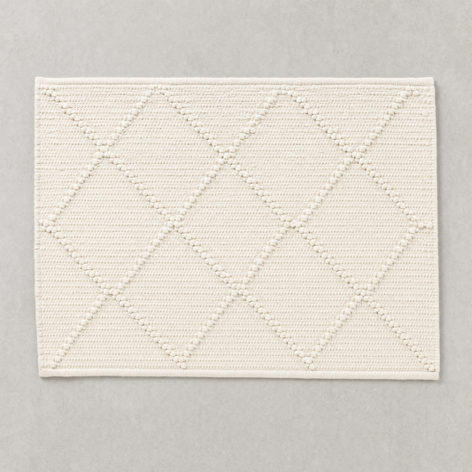 Open Diamond Mat in warm white: knotted diamond outlines over a flat woven cotton ground